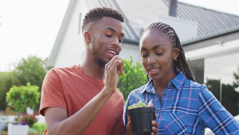 Feliz-Pareja-Afroamericana-Con-Brotes-De-Plantas-En-El-Patio-Trasero