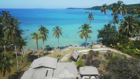 koh-kood-resort-Coconut-palms-in-front-of-blue-turquoise-lagoon-with-crystal-clear-water