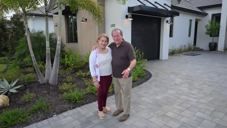 happy customers wave in front of their house