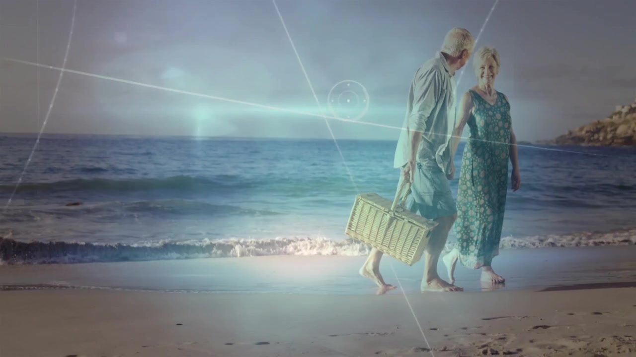 Senior couple walking shore with basket for picnic walking causing glow overlaying scene travel ad