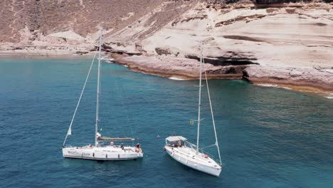 sail yacht lifestyle anchored at rocky shore of atlantic ocean island, aerial