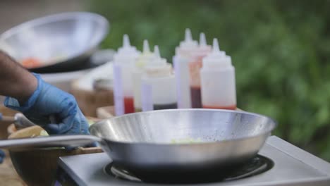 crop man frying vegetables outside