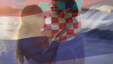 composite video of waving croatia flag against caucasian couple embracing each other at the beach