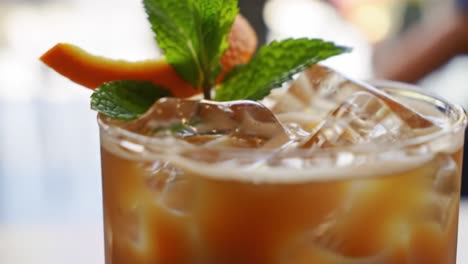 refreshing cold beverage with mint and citrus garnish served over ice in a clear glass, perfect for quenching thirst on a hot day