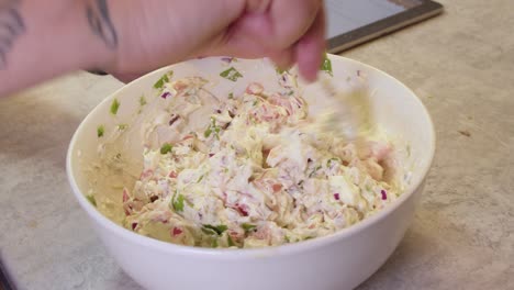 cooking a creamy salad in a white bowl