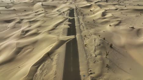Rückwärts-Geneigte-Luftaufnahme-über-Der-Sandigen-Halbwüstenstraße-Im-Sonnigen-Dubai,-Vereinigte-Arabische-Emirate