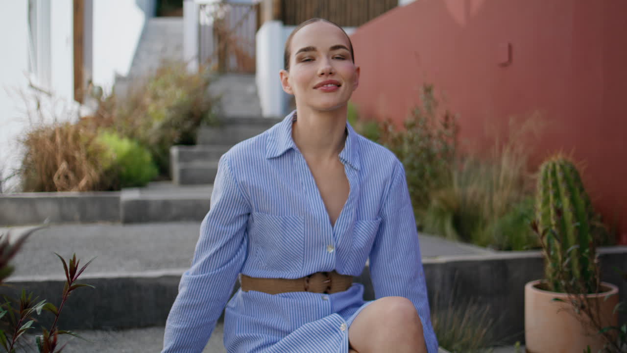 Gentle model sitting stairs looking camera at old town summer street portrait