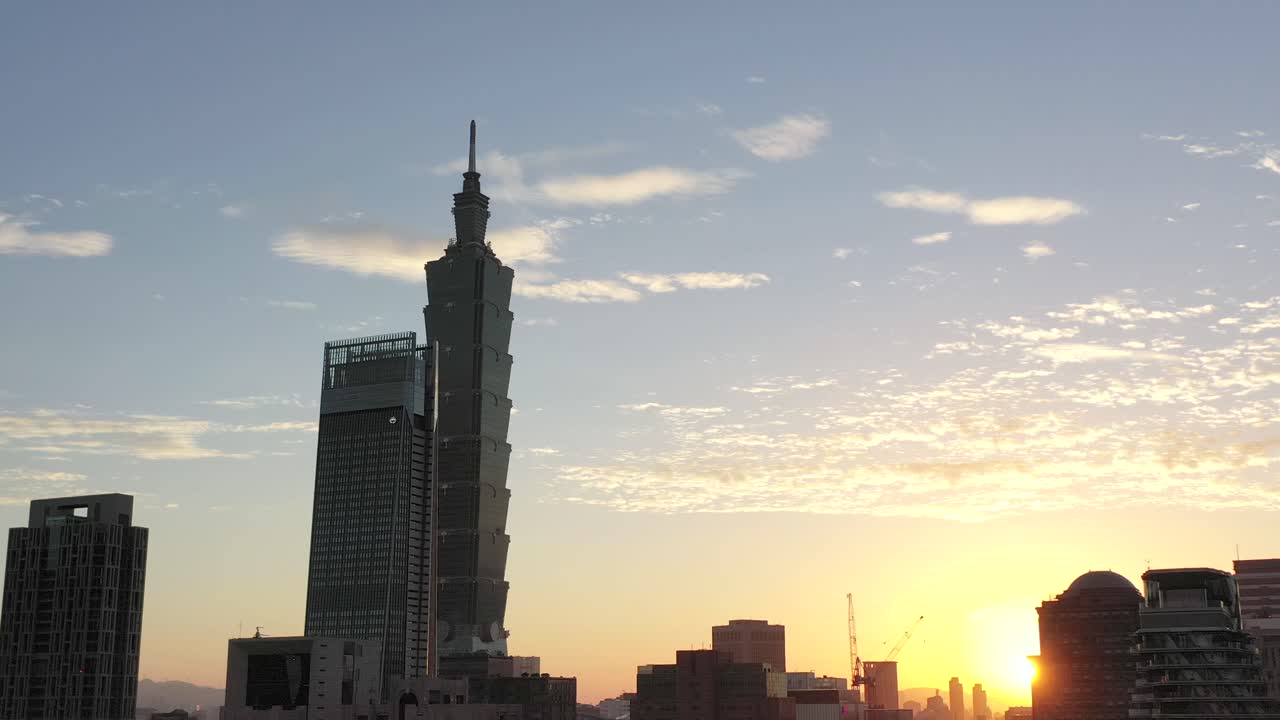 toma de seguimiento aéreo cinematográfico que captura el paisaje urbano y el edificio más alto taipei 101 en el distrito céntrico de xinyi, taiwán, en las horas doradas del atardecer