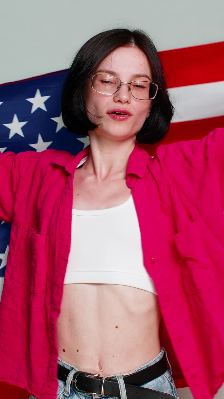 Young woman joyfully waving american usa flag with smile expressing patriotism support pride emotion