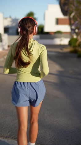 woman running outdoors with headphones