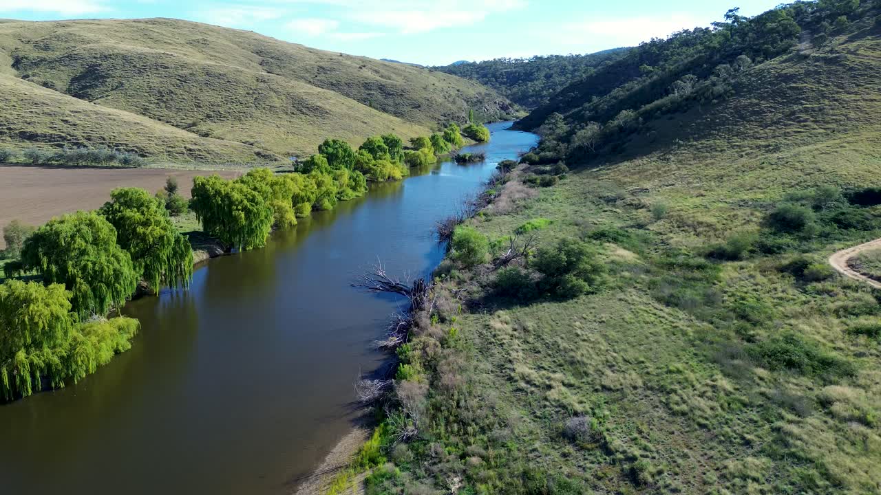 Drone aerial landscape of trees and mountainous valley along Murrumbidgee riverbank embankment water inlet stream creek in countryside town Bredbo NSW Australia nature outdoors wilderness Cooma