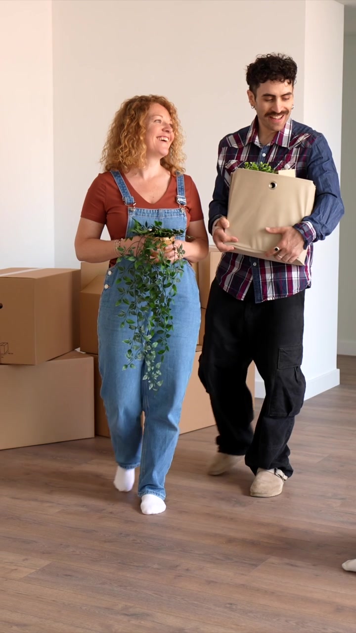 Happy Couple Moving Into New Home With Cardboard Boxes