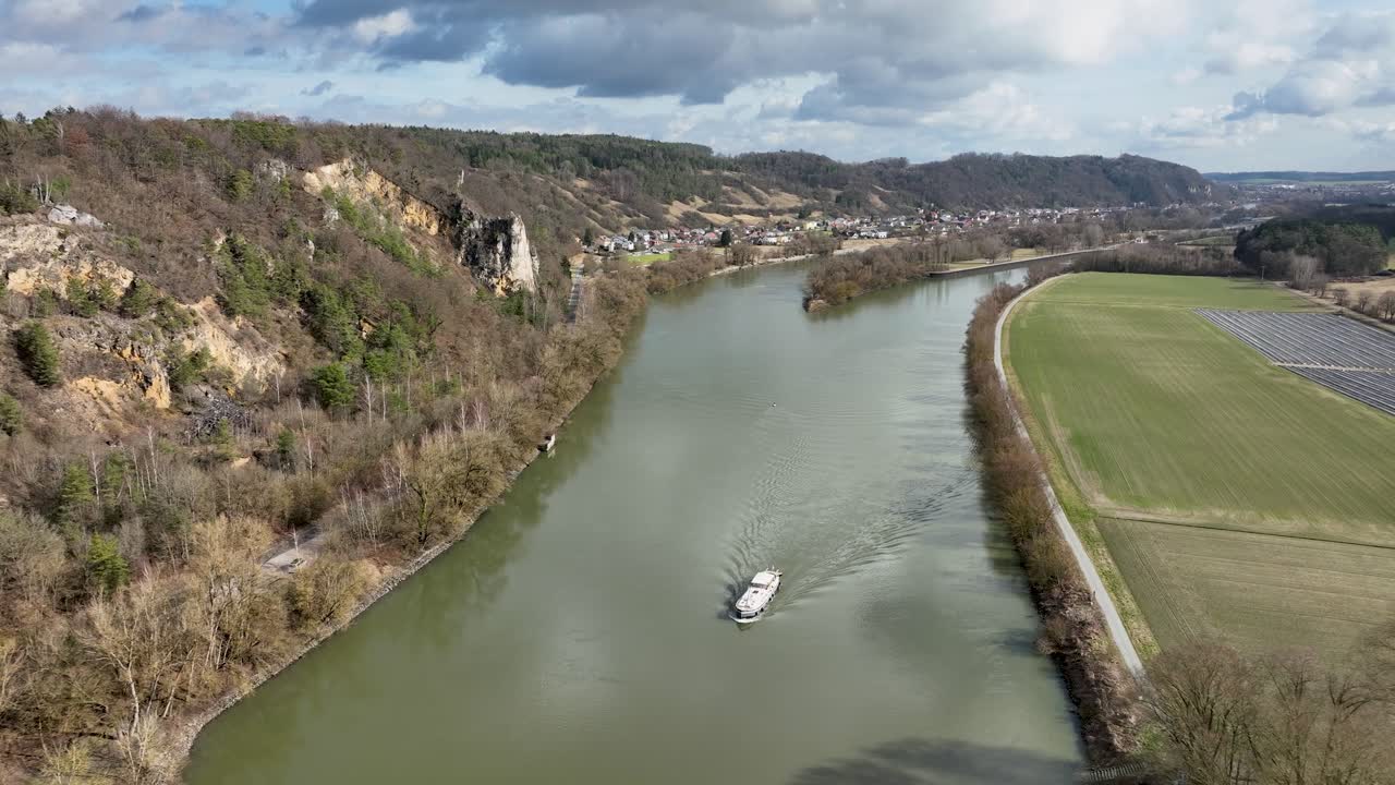 A beautiful aerial shot of a boat on the Danube River, showing the importance of the waterway in a setting of breathtaking natural beauty
