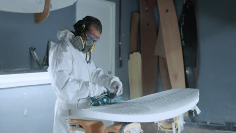 professional master polishing surfboard in workshop