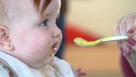 slow motion baby with dirty face of baby food looking out of plane turns his head