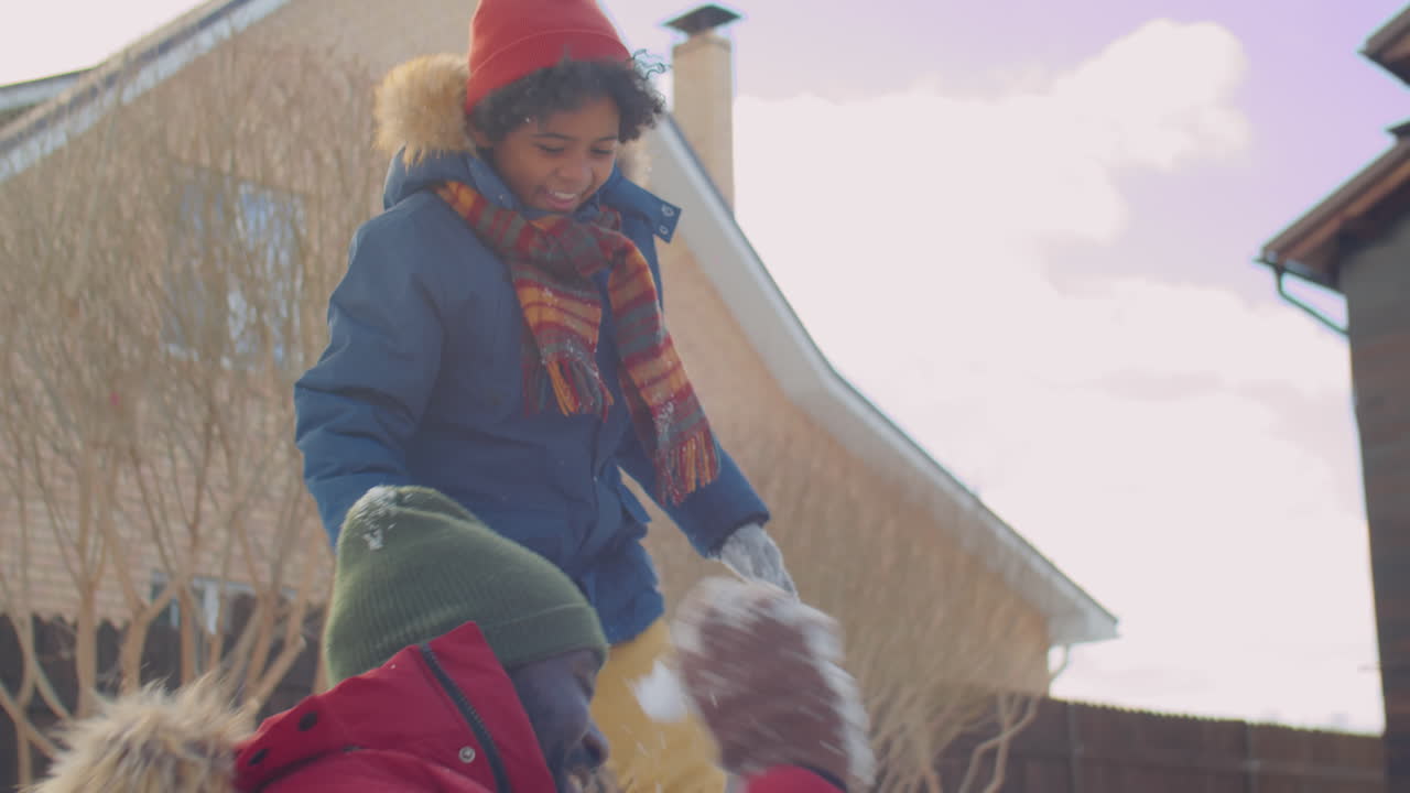 Black Family Playing Snowballs and Having Fun on Winter Day