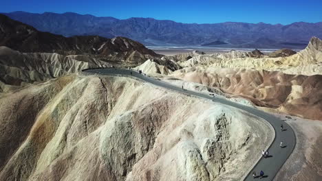 Sobrevuelo-Aéreo-De-Turistas-Caminando-Hasta-La-Cima-De-Zabriskie-Point,-Parque-Nacional-Del-Valle-De-La-Muerte