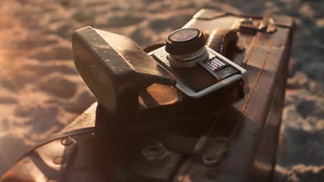 animation of light over camera lying on suitcase on beach