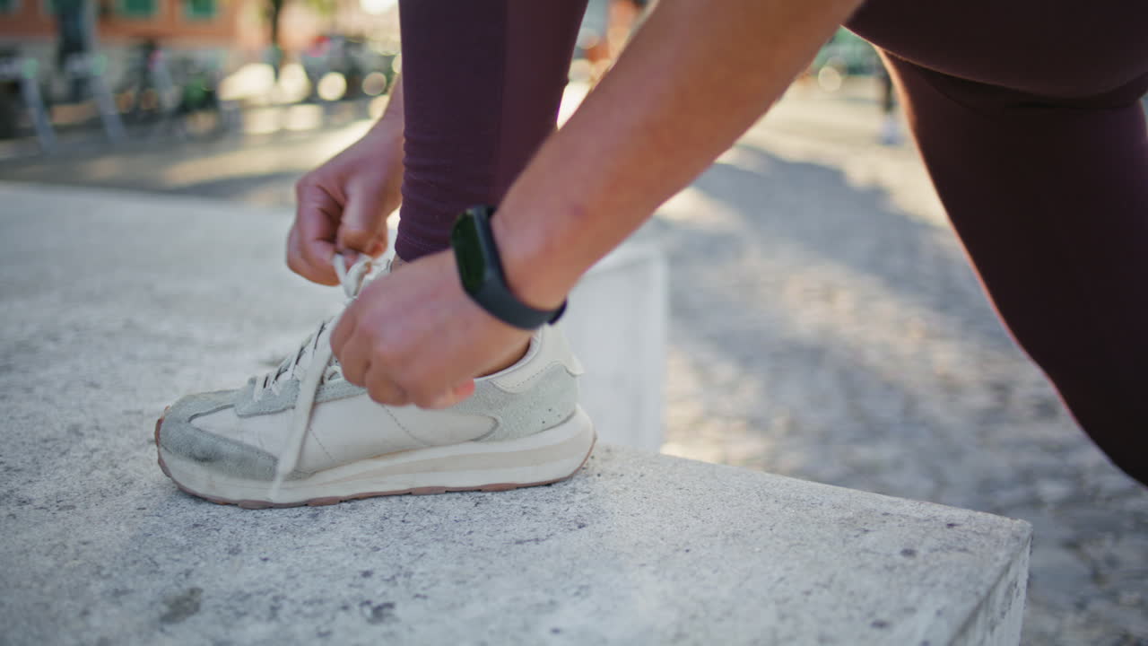 여자 손이 운동화에 을 는 야외 클로즈업. 달리기 선수가 신발을 고 있다.