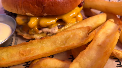 Köstlicher-Doppel-Cheeseburger-Mit-Pommes-Und-Soße,-Fastfood-Restaurant,-Ungesundes-Essen,-4K-Aufnahme