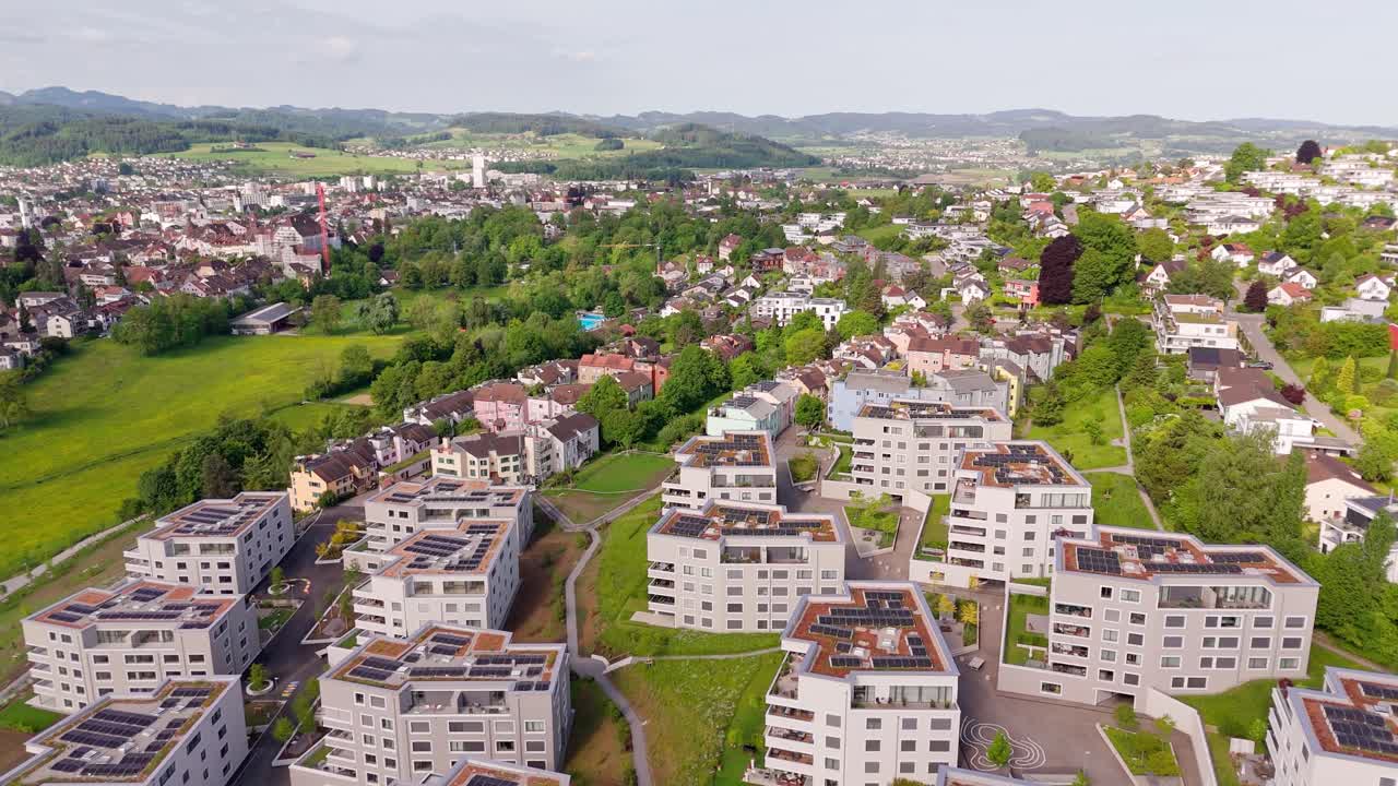 Luxury Apartment blocks with green green rooftop and solar panels. Production of green energy theme. Swiss city during sunny day in summer. Similar real estates buildings in Switzerland. Aerial view.