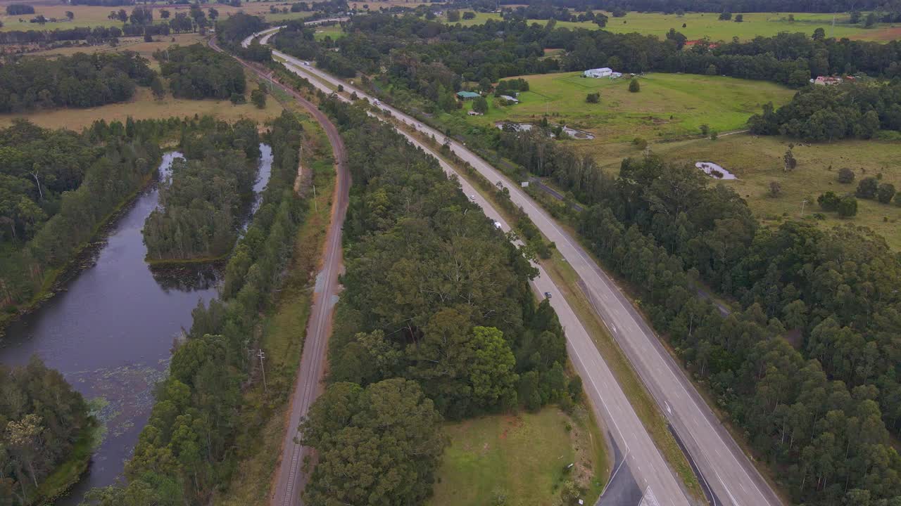 vista aérea de los automóviles que circulan por la autopista del pacífico pasando por la localidad del río johns cerca del parque nacional del hermano medio, nsw, australia