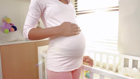 pregnant woman looking at new cot