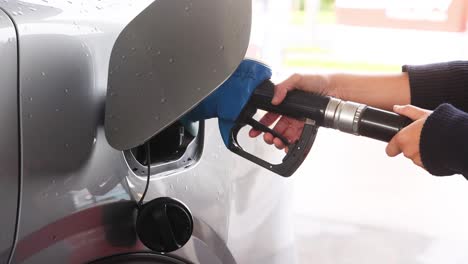 person refueling car at melbourne gas station