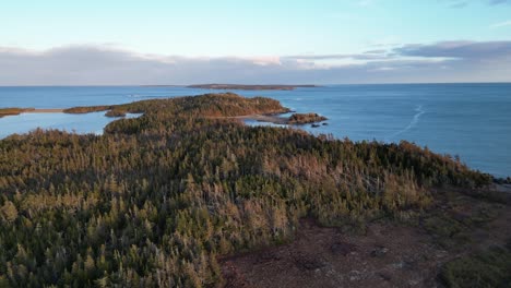 a fly over of mira bay from scatarie island, flying towards a small town over looking the ocean