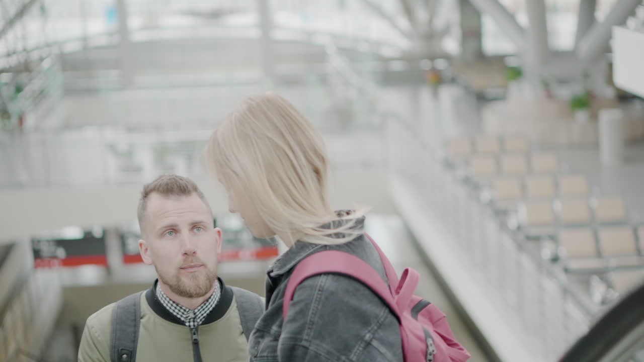 пара поднимается по эскалатору в аэропорту