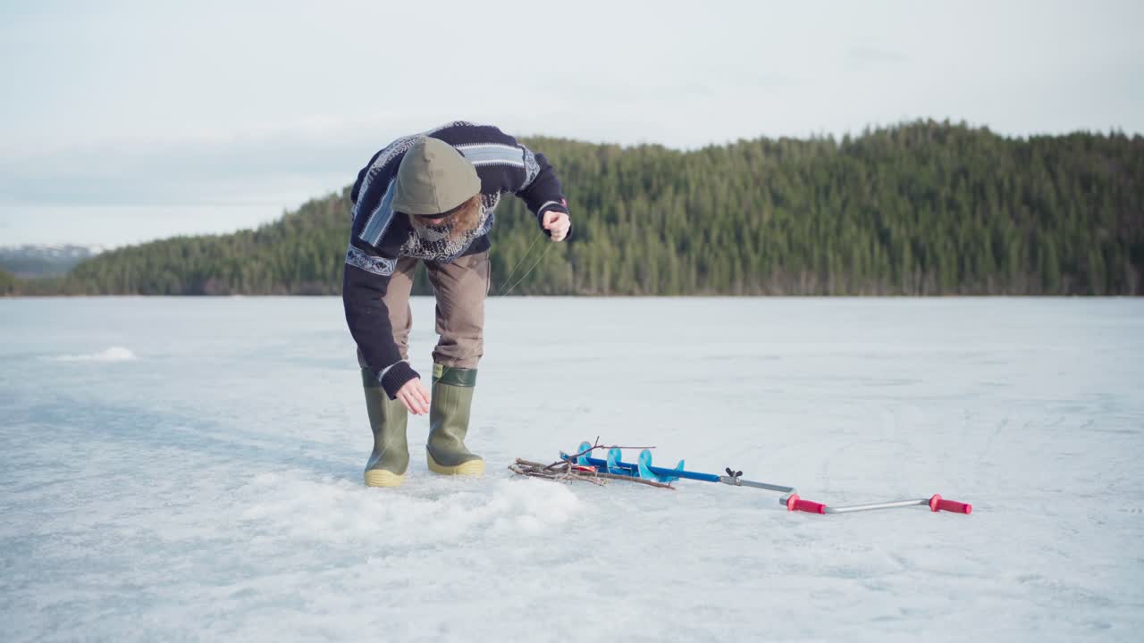 Isfiskeri - Mand fangede en fisk på frossen sø.