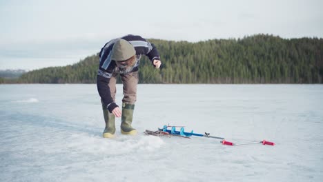 ice fishing - man caught a fish on frozen lake