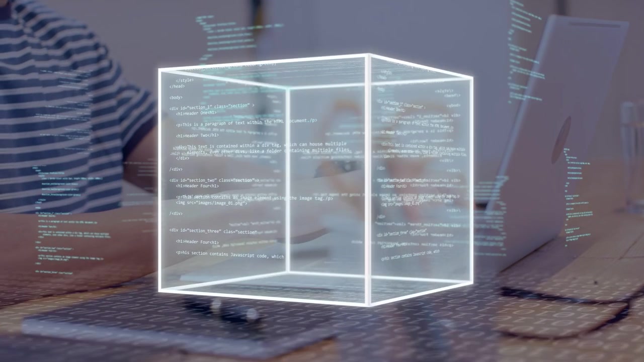 Man typing on laptop at desk, starting wireframe cube appearing growing rotating showing tech data