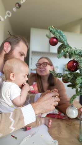 family decorating a small christmas tree