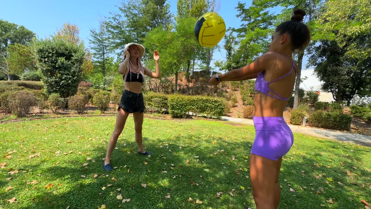 Two women playing with a ball in the park