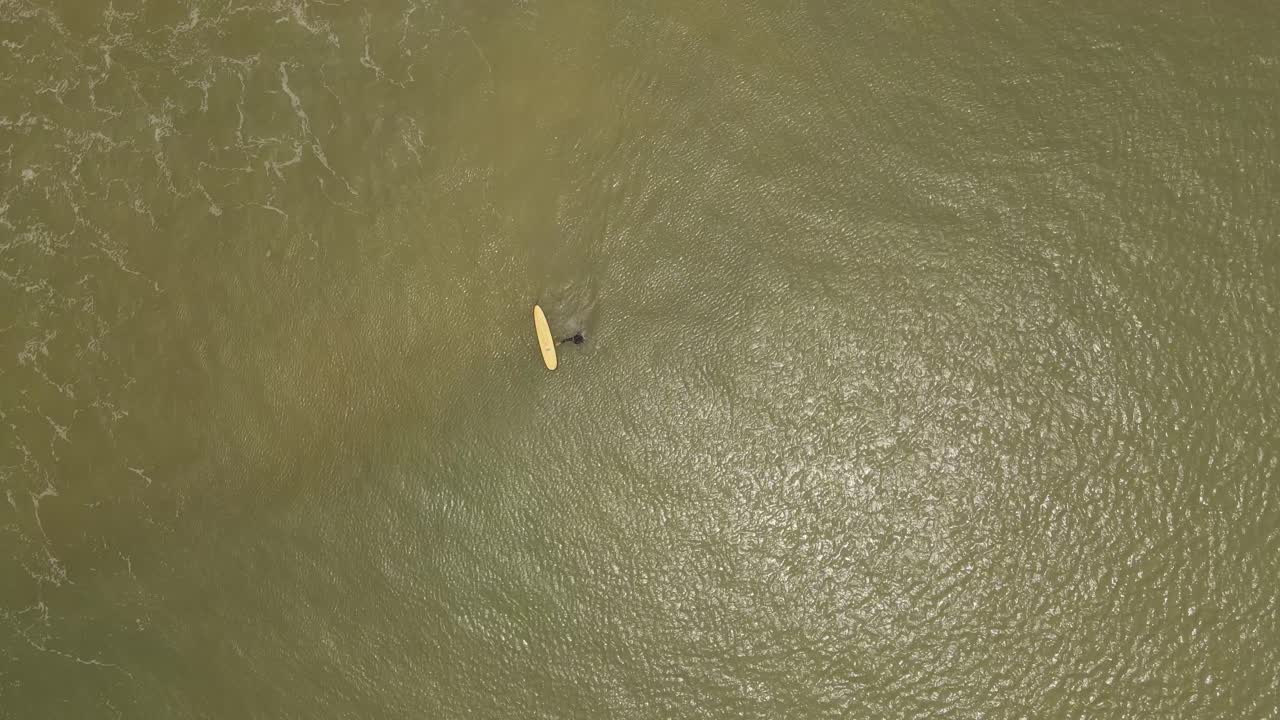 surfista aislado e irreconocible entra en el agua del océano