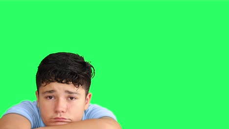 sad teenager looking at camera at green screen background 1