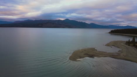 Lago-Kluane-Durante-La-Colorida-Puesta-De-Sol-En-Invierno,-Tiro-De-Drones-Volando-A-La-Izquierda