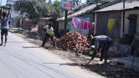 poor indian wage workers doing labour work at construction site at hot sunny day