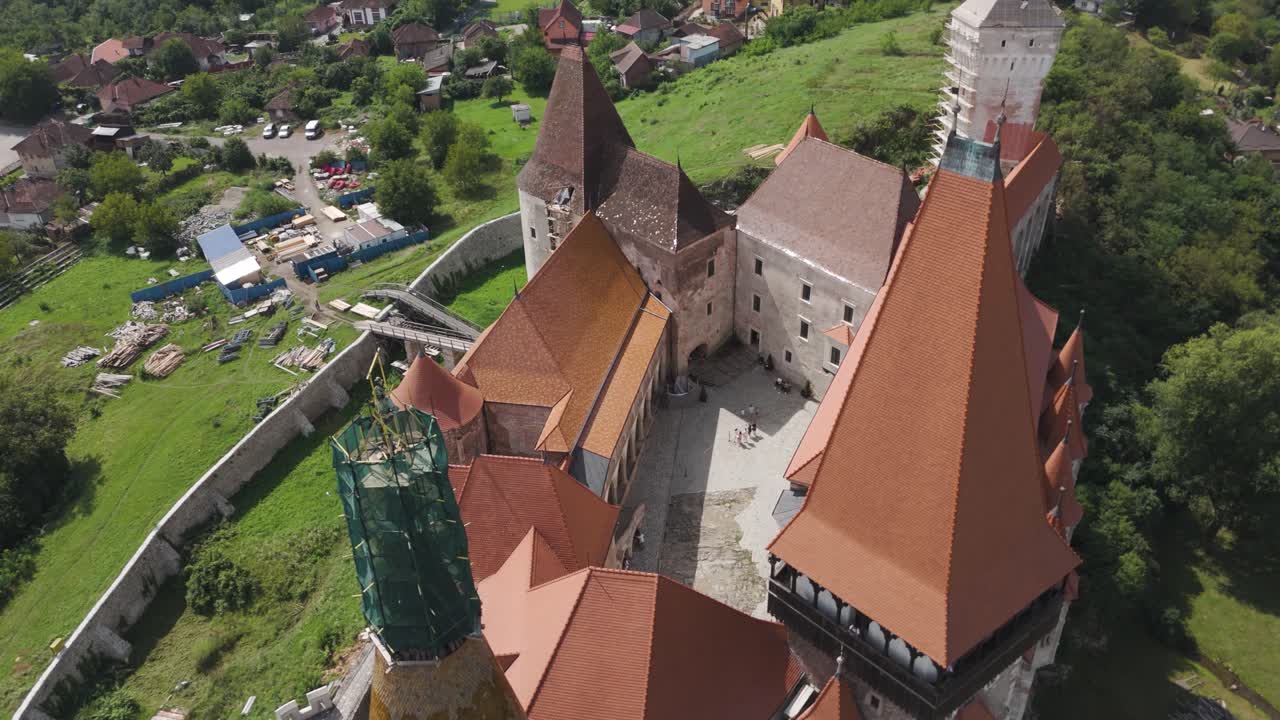 Top-down view of Corvin Castle’s inner courtyard, emphasizing stonework, rooftops, and visitors