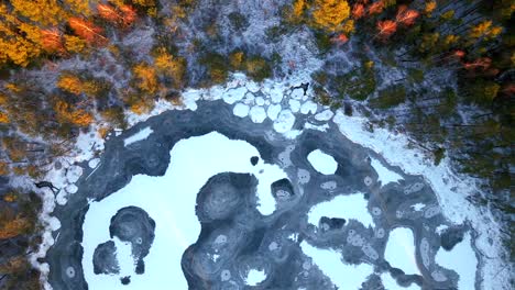 frozen swamp in a forest, aerial shot of snow patches covering the winter landscape