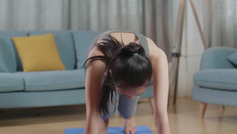 joven entrenadora asiática mujer en ropa deportiva hablando antes de hacer cardio rodillas altas y fortalecimiento del núcleo mientras enseña ejercicios en casa