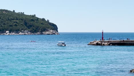 A-speedboat-with-people-leaving-the-Old-town-port-in-Dubrovnik-during-the-summer,-Dalmatia,-Croatia