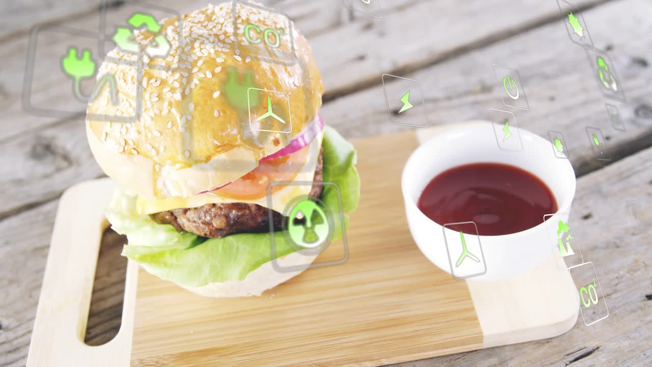 ごま付きハンバーガーが置かれ、右上から緑のアイコンが漂い、回転しながら現れ、環境への影響を示しています。