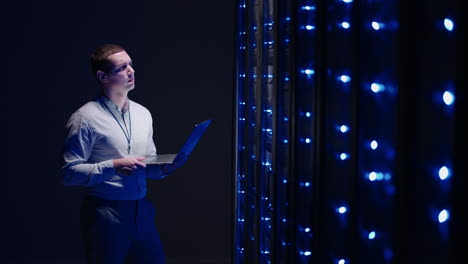 técnico informático en el centro de datos sala de servidores digitales controlando el trabajo de los gabinetes de servidores de rack con una tableta. ingeniero profesional de servidores en el trabajo. técnicos de hombre que trabajan en la sala de servidores de alta tecnología