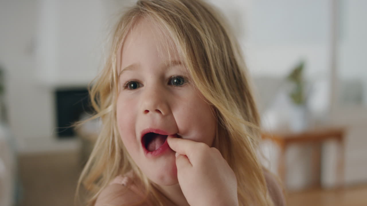 ritratto di una ragazzina divertente che fa facce sciocche guardando la telecamera un bambino felice che gioca godendo l'infanzia divertendosi a casa 4k