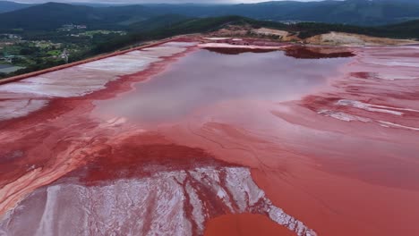 reflections on waters of red mud pond at alcoa reservoir in lugo, spain. aerial shot