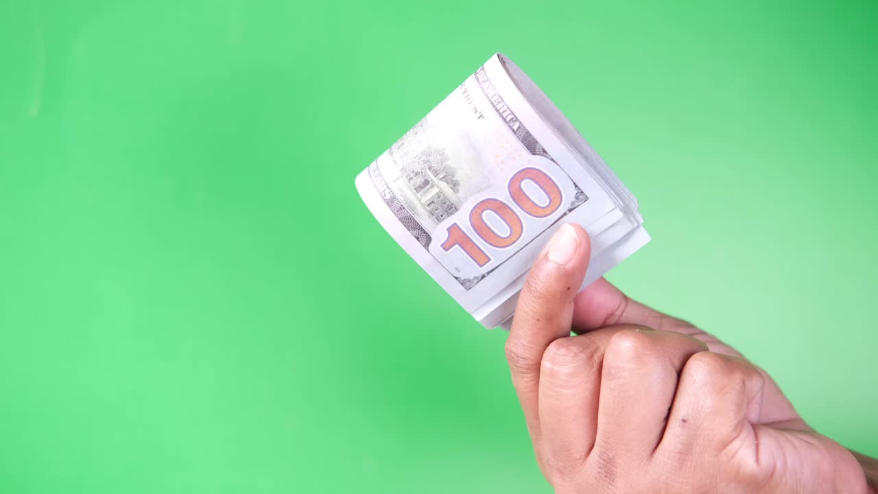 우리에게 100달러 지폐를 들고 있는 손