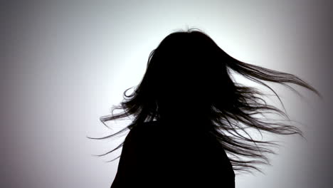 silhouette of attractive woman tossing her hair