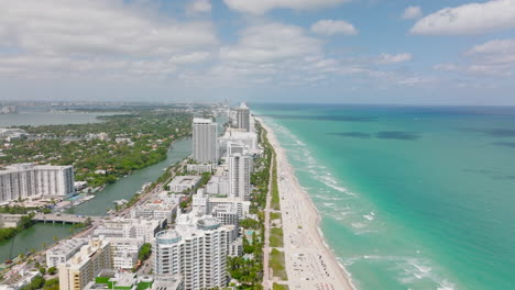 Aerial-panoramic-view-of-high-rise-buildings-along-sea-coast.-Modern-city-borough-with-hotels-and-vacation-resorts.-Miami,-USA